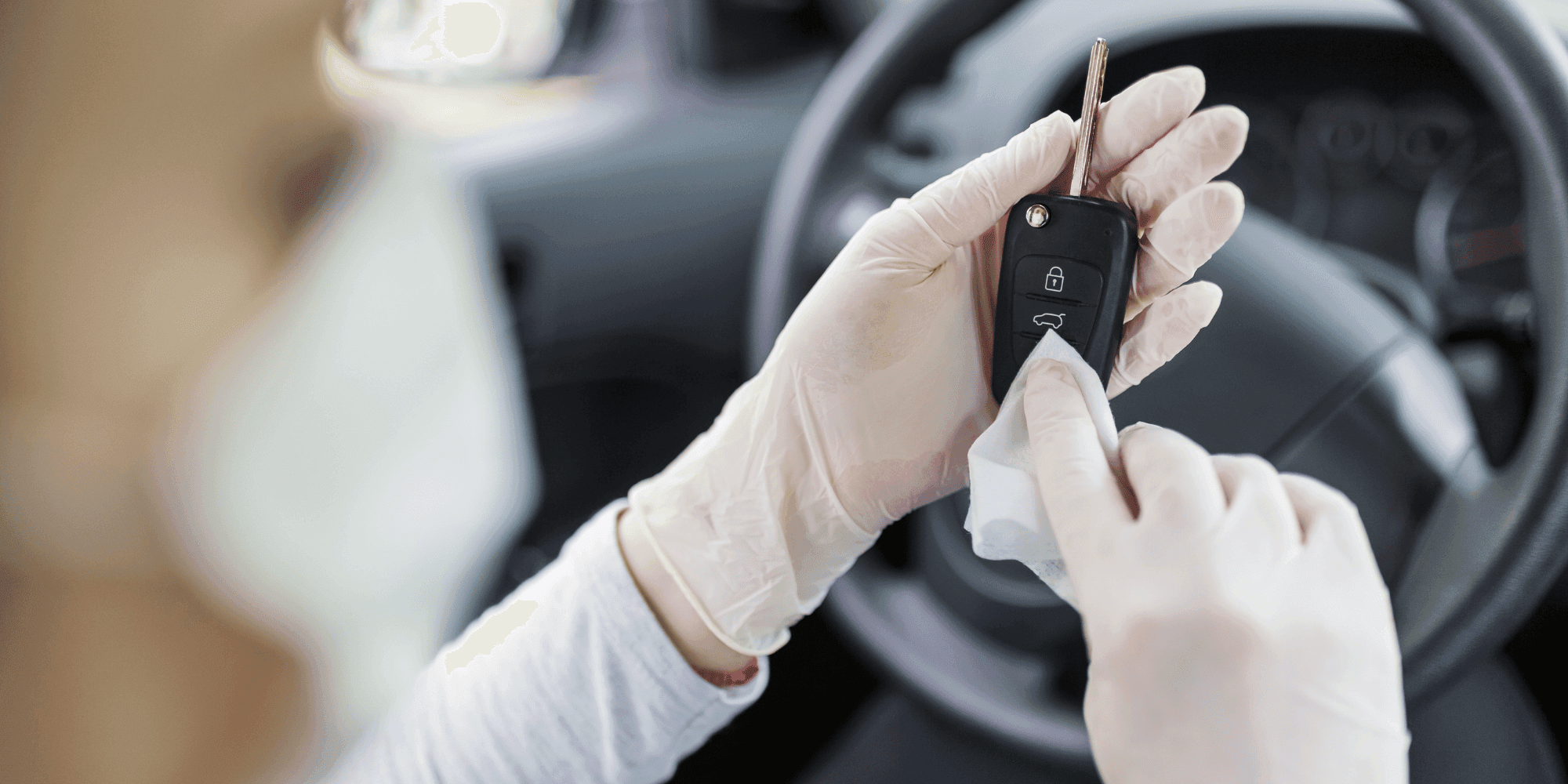Person wearing gloves disinfects a car key in the interior of a car. copyright iStock / zoff-photo