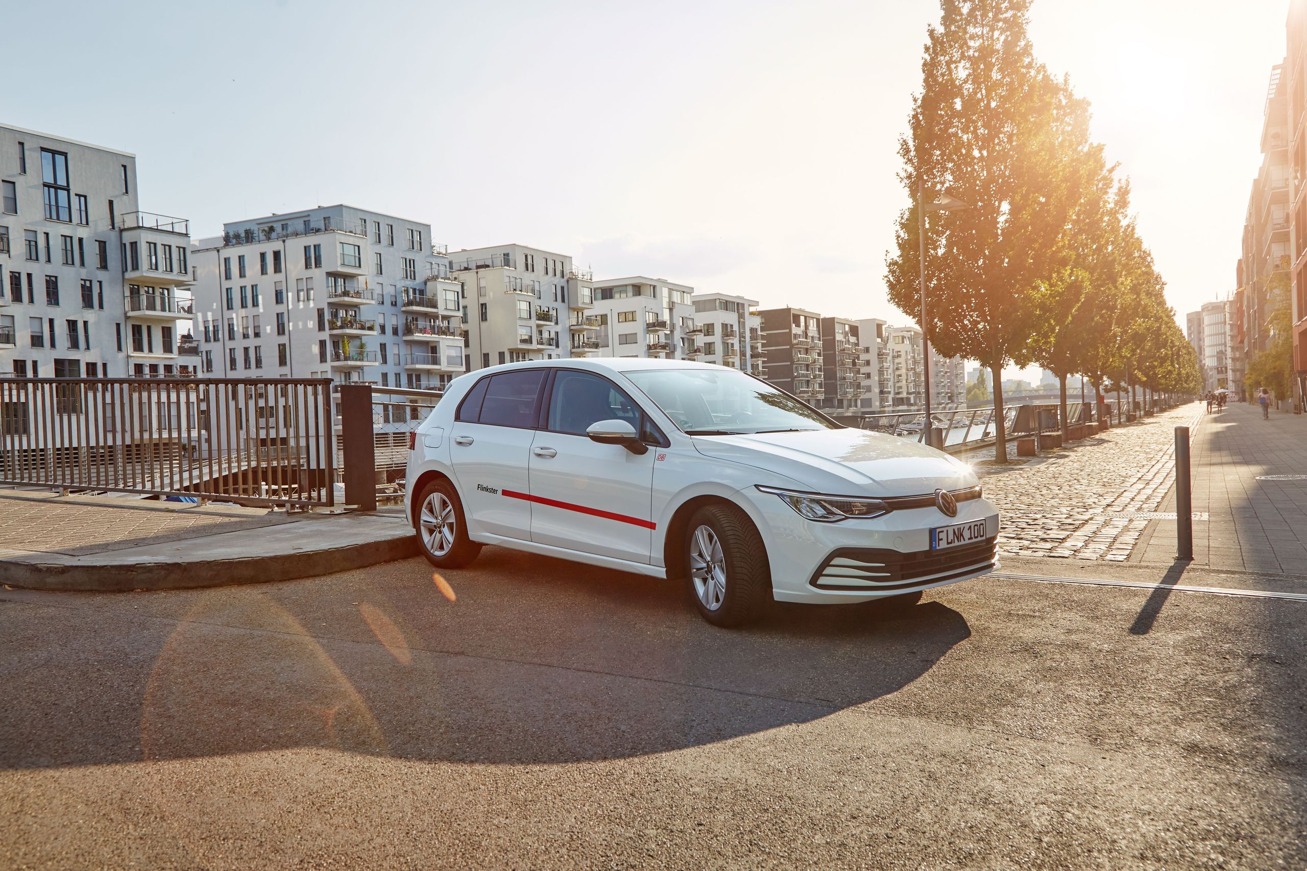 Parked Flinkster car in a modern city district at sunset.